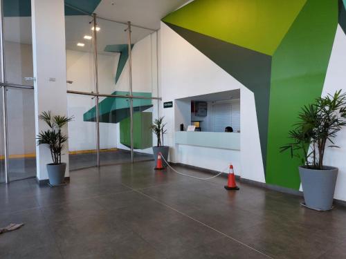 a lobby with two potted plants and a green wall at Balcones Verdes 2407 in Salta