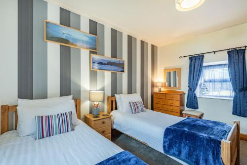 sypialnia z dwoma łóżkami i oknem w obiekcie Stables Cottage w mieście Llanrwst