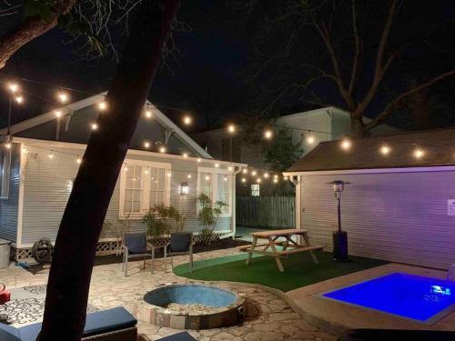 a backyard with a table and a fire pit at night at Pershing Place: Historic home with heated spa/pool by Zoo, Pearl, Golf, Witte in San Antonio