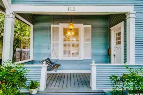 a blue house with a bench on a porch at Pershing Place: Historic home with heated spa/pool by Zoo, Pearl, Golf, Witte in San Antonio