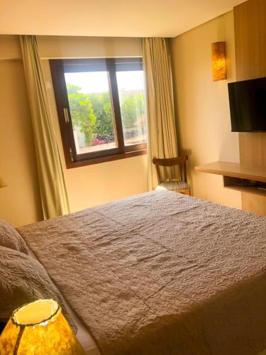 a bedroom with a large bed and a window at Kariri Beach - 207 - Praia do Cumbuco, Caucaia in Cumbuco