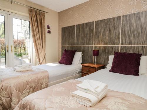 two beds in a room with a window at Riverside in Coniston