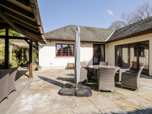a patio with a table and chairs and a umbrella at Riverside in Coniston