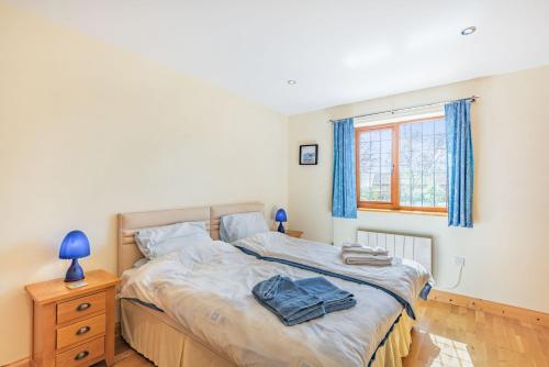 a bedroom with a bed and a blue lamp and a window at Garden Cottage in Spilsby