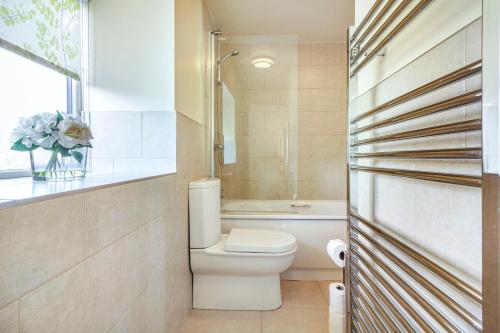 een badkamer met een toilet en een bad bij Smithy Cottage in Bradwell