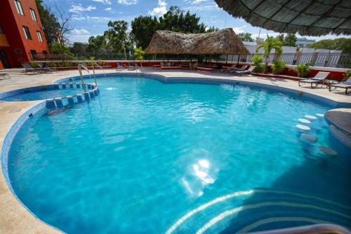 a large pool with blue water in a resort at Holiday Inn Merida by IHG in Mérida