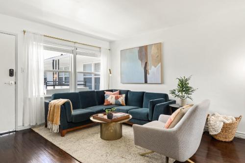 a living room with a blue couch and two chairs at Spacious Coastal Apartment in a Colorful Community - NRP22-00590 in Long Beach