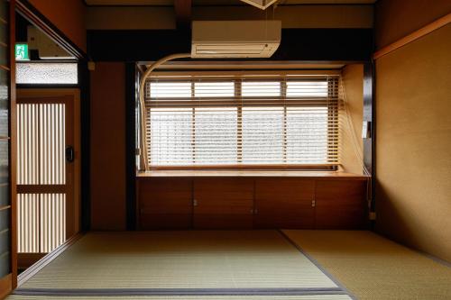 pusty pokój z oknem i drzwiami w obiekcie Kyoto Cosy House 1946 by YADORU KYOTO HANARE w mieście Kioto