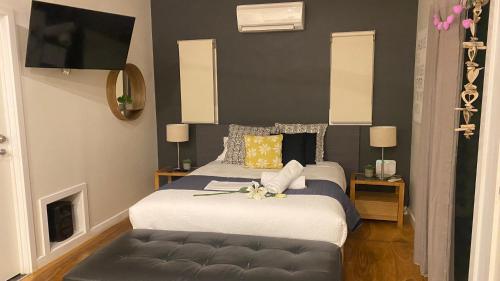 a bedroom with two beds and a couch at Couple's Resort Spa Retreat in Cowes