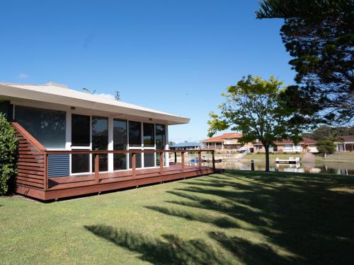 a house with a large deck in a yard at Mounties @ Sussex in Sussex inlet