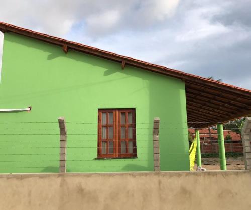 a green house with a window on the side of it at Mar Aberto_chale 3 in Barroquinha