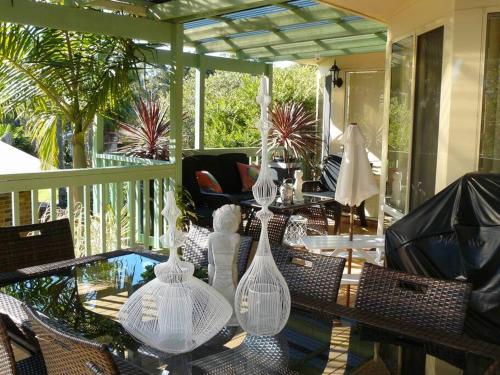 a glass table with several glass vases on a porch at LILLI PILLI SUBLIME Family and Dog Friendly by the Beach in Batemans Bay