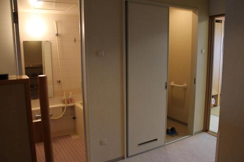 a bathroom with a toilet and a sink and a mirror at LiVEMAX RESORT Hakodate Greenpia Onuma in Mori