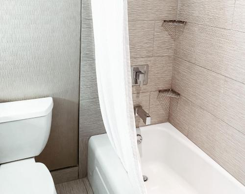 a bathroom with a white toilet and a shower at Crowne Plaza Chicago SW - Burr Ridge by IHG in Burr Ridge
