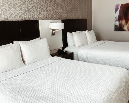 a hotel room with two beds with white pillows at Crowne Plaza Chicago SW - Burr Ridge by IHG in Burr Ridge