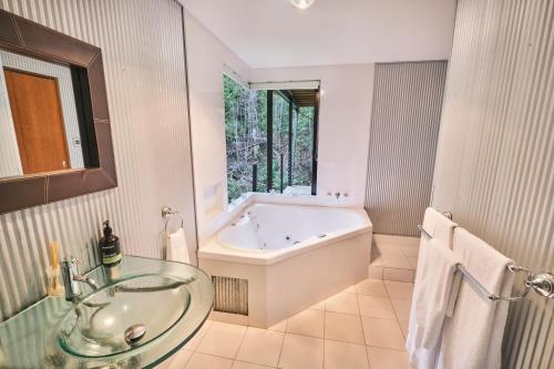 a bathroom with a tub and a glass sink at EcOasis in Uki