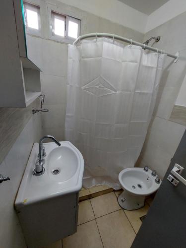 a white bathroom with a sink and a toilet at Departamento Las3B 5 in General Roca