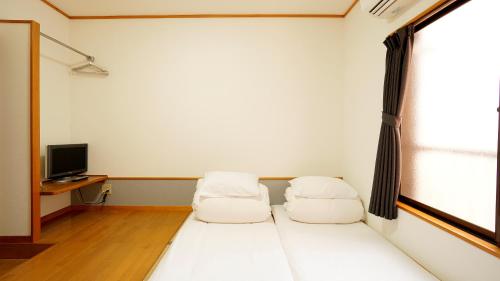 two beds in a room with a window at House Ikebukuro in Tokyo