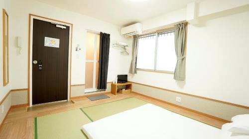 an empty room with a door and a window at House Ikebukuro in Tokyo