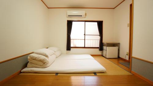 a small room with a bed with a window at House Ikebukuro in Tokyo