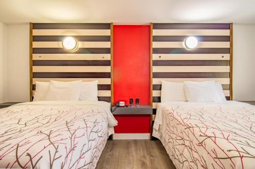 a hotel room with two beds and a red wall at The Asheville Inn in Asheville