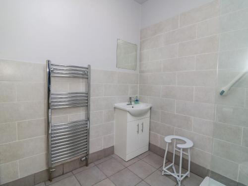 a bathroom with a sink and a mirror and a stool at Shamrock in Selby