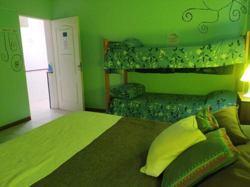 Dormitorio verde con cama y sofá en COMPLEJO ALOHA en Puerto Pirámides