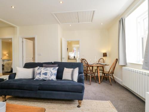 a living room with a blue couch and a table at The Bakers Loft in Ambleside