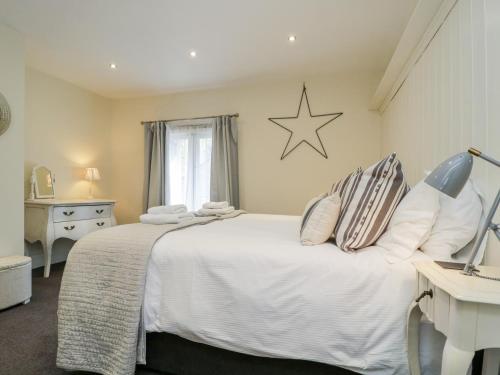 a bedroom with a white bed and a star on the wall at The Bakers Loft in Ambleside