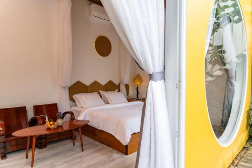 a bedroom with a bed and a table and a window at Binh Minh Eco Lodge in Can Tho