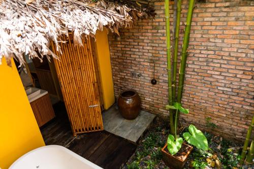 a bathroom with a toilet and a brick wall at Binh Minh Eco Lodge in Can Tho