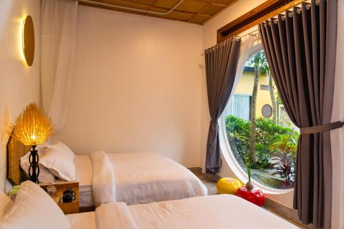a bedroom with two beds and a large window at Binh Minh Eco Lodge in Can Tho