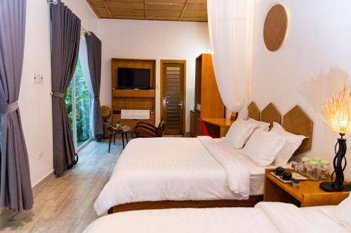 a hotel room with two beds and a tv at Binh Minh Eco Lodge in Can Tho