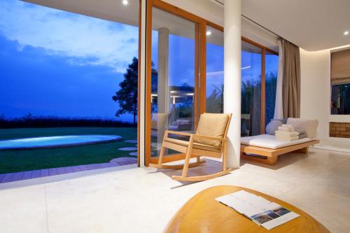 a living room with a view of a pool at Sala Khaoyai in Wangkata