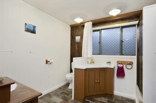 La salle de bains est pourvue d'un lavabo et de toilettes. dans l'établissement Browns Cottage, à Bilpin