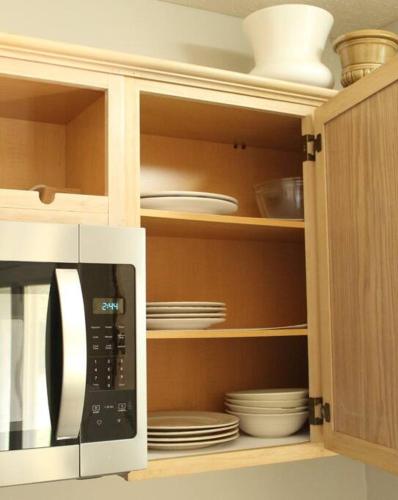 a microwave in a kitchen with plates and dishes at Cheerful 2-Bedroom, 2 bath with private parking in Fayetteville