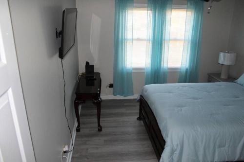 a bedroom with a bed and a television and a chair at Cheerful 2-Bedroom, 2 bath with private parking in Fayetteville