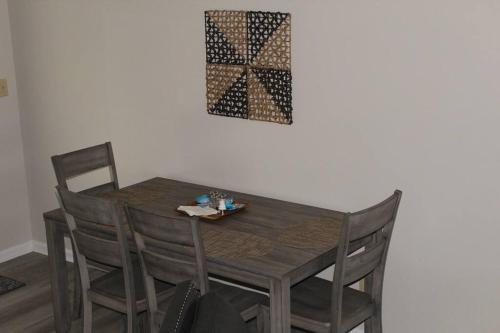 a wooden dining room table with chairs and a picture on the wall at Cheerful 2-Bedroom, 2 bath with private parking in Fayetteville