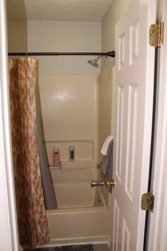 a bathroom with a shower with a shower curtain at Cheerful 2-Bedroom, 2 bath with private parking in Fayetteville