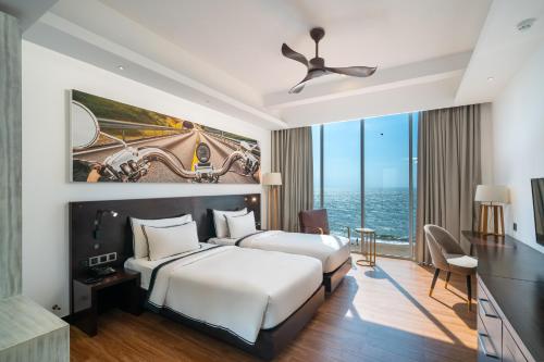 a hotel room with two beds and a large window at Regal Réseau Hotel & Spa in Negombo