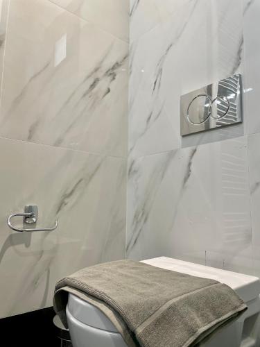 a bathroom with a toilet and a marble wall at KYRIAKOS APPARTMENT in Monemvasia