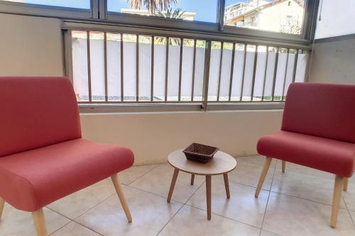 deux chaises et une table devant une fenêtre dans l'établissement HENRI CAMILLE REAL ESTATE - Latour - Studio 150m Martinez, à Cannes
