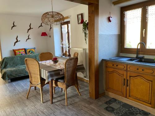 a kitchen and dining room with a table and chairs at Au Nid Des Pies in Soultzeren