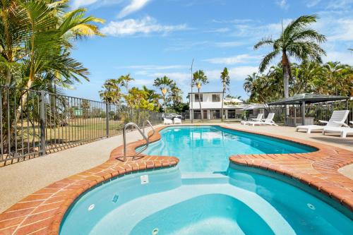 a large swimming pool with a resort at Kinka Palms Motel in Yeppoon