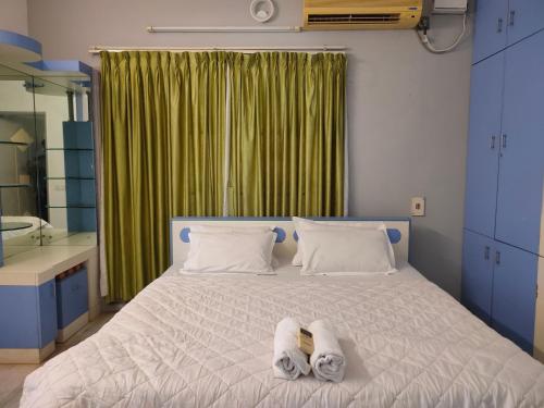 een slaapkamer met een bed met twee slippers erop bij PRAVESH VILLA in Pondicherry
