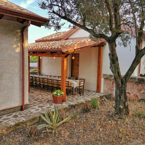 a patio with a table and chairs and a tree at Borgo Santa Lucia in Cropani