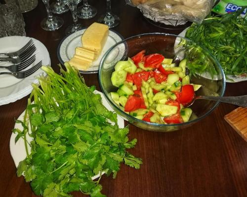 a table with a bowl of vegetables and a bowl of cheese at EleGaya Guest house in Ijevan