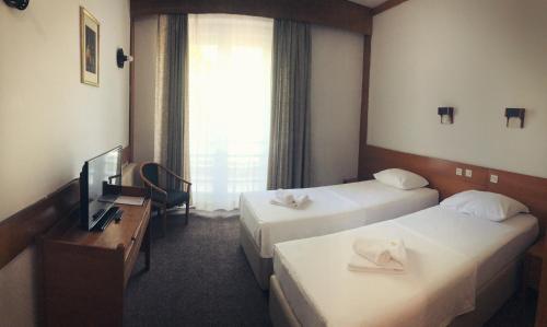 um quarto de hotel com duas camas e uma televisão em Hotel Onogošt em Nikšić