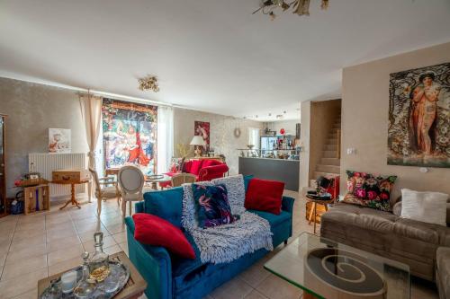 a living room with a blue couch and red pillows at lamaison-d'ose in Romans