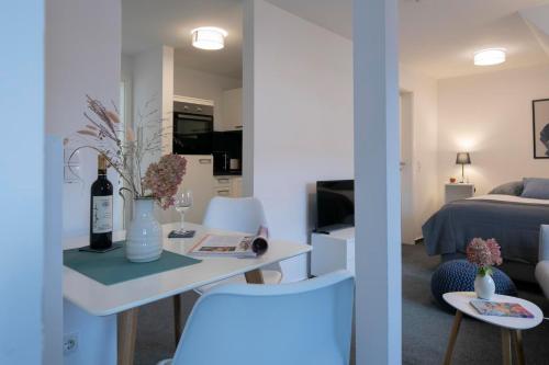 a living room with a table with a bottle of wine at Weberhof Ferienapartments in Rostrup am Westufer des Zwischenahner Meers in Bad Zwischenahn